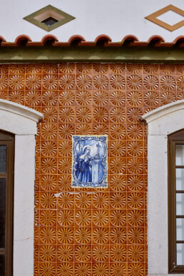 facade of a typical portugese house in the algarve with ceramic tiles and a mother mary print